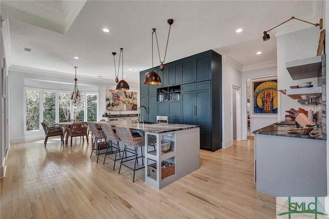 kitchen featuring light wood-style floors, a breakfast bar area, open shelves, and crown molding