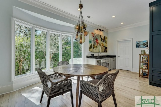 dining space featuring ornamental molding, recessed lighting, light wood-style floors, and baseboards