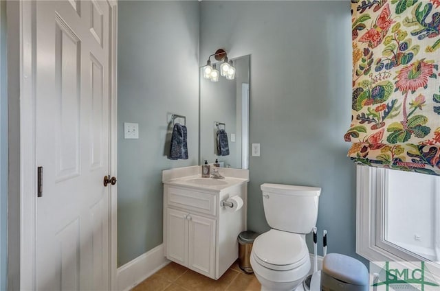 bathroom with vanity, tile patterned flooring, toilet, and baseboards