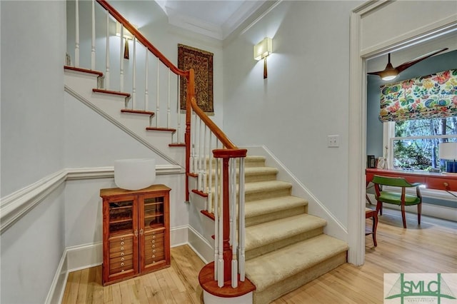 stairs with crown molding, baseboards, and wood finished floors