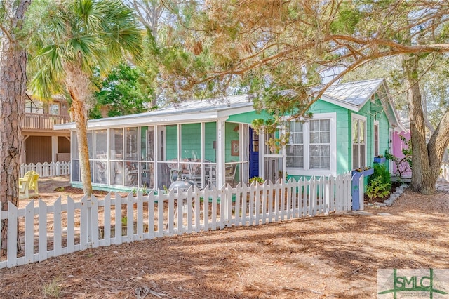 view of front of home with a sunroom and a fenced front yard