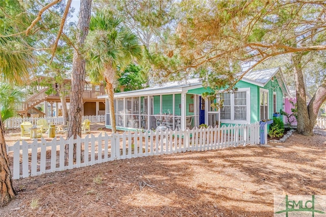 view of front of house with a fenced front yard and a sunroom