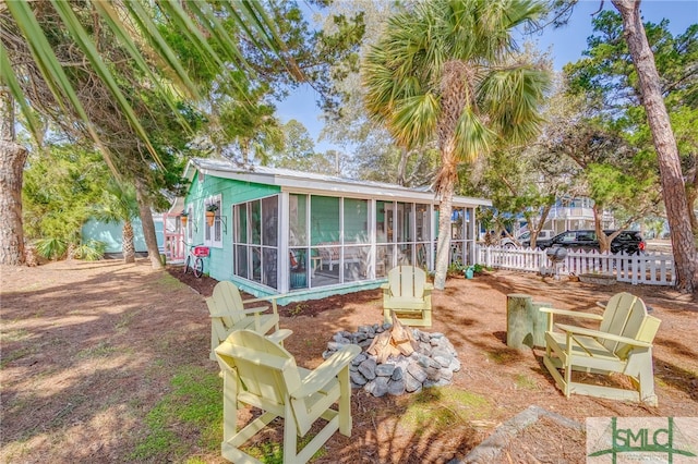 back of house featuring fence and a sunroom