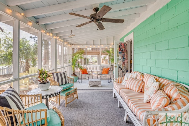 unfurnished sunroom featuring lofted ceiling with beams and a ceiling fan