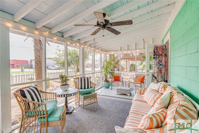 sunroom / solarium featuring lofted ceiling with beams and a ceiling fan