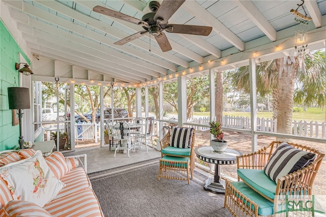 sunroom with lofted ceiling with beams and ceiling fan