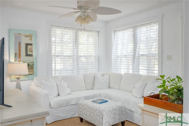 living area featuring ornamental molding and a ceiling fan