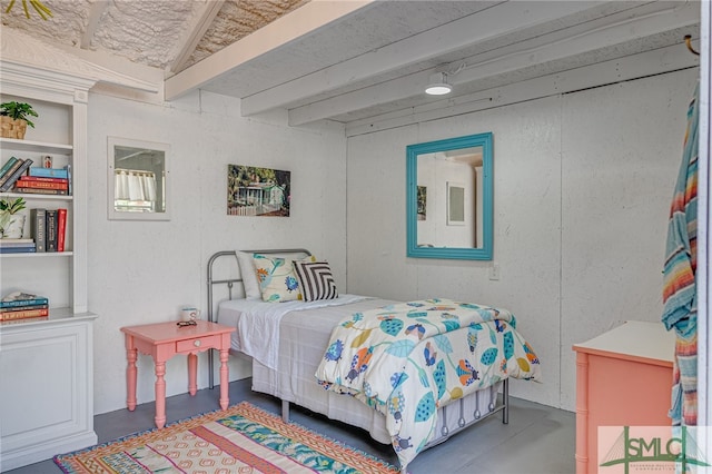 bedroom with finished concrete floors and beam ceiling