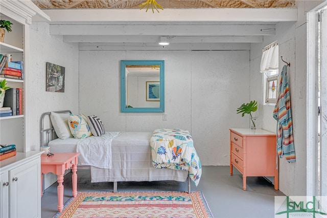 bedroom with concrete floors and beamed ceiling