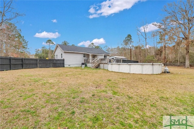 back of property with a lawn, crawl space, a fenced backyard, and a fenced in pool