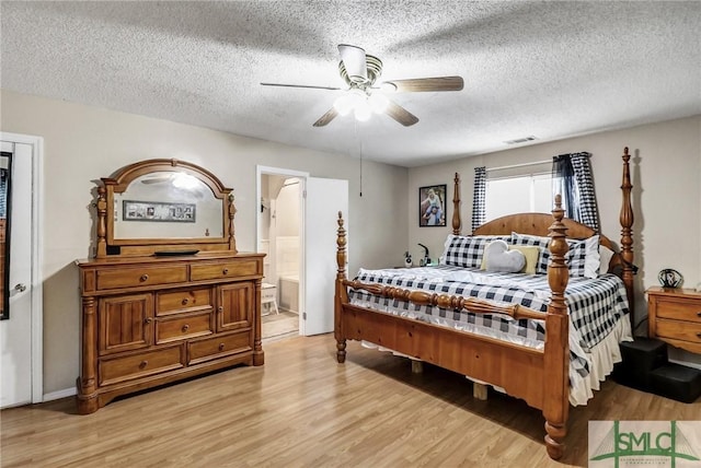 bedroom featuring light wood-type flooring, ceiling fan, visible vents, and a textured ceiling