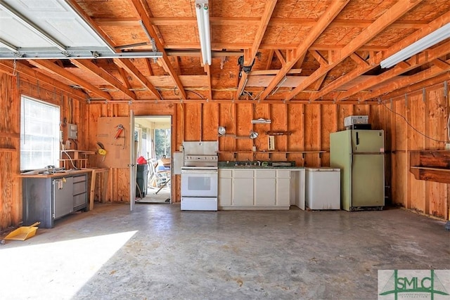 garage with a sink, freestanding refrigerator, and refrigerator