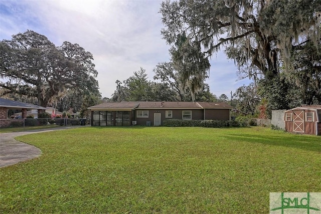 view of front of home with a sunroom, fence, and a front lawn