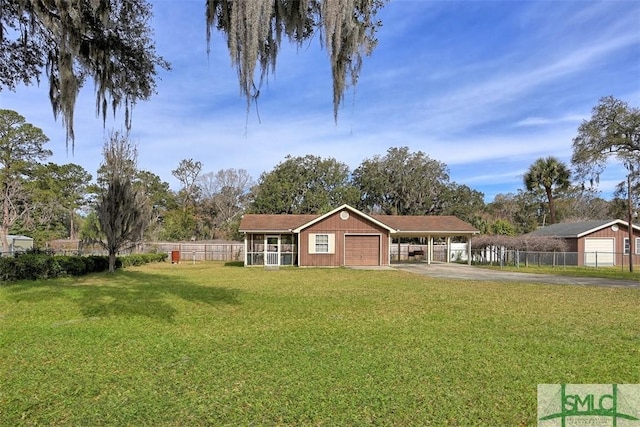 view of front of property featuring driveway, a garage, fence, a carport, and a front yard