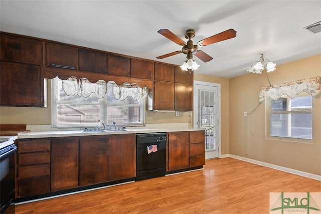 kitchen with black dishwasher, light countertops, a sink, and visible vents