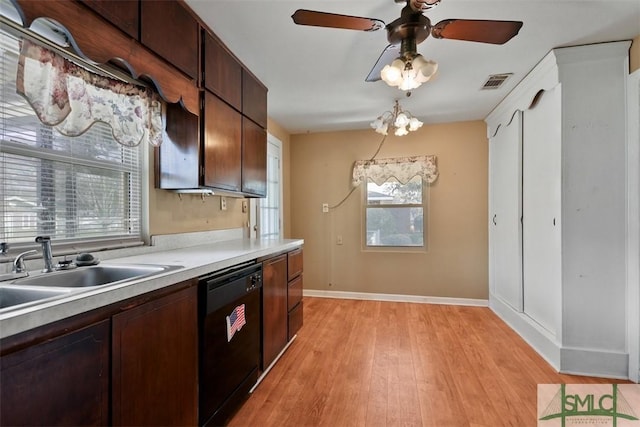 kitchen featuring a sink, visible vents, light wood-style floors, black dishwasher, and light countertops