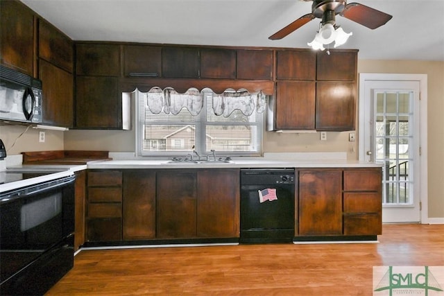 kitchen featuring black appliances, light countertops, and light wood-style flooring