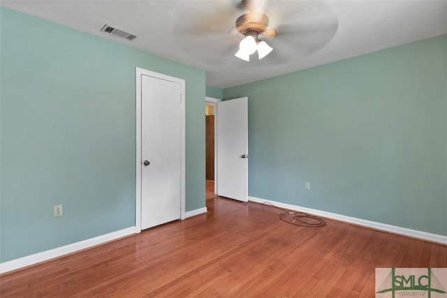 unfurnished bedroom with baseboards, visible vents, ceiling fan, and wood finished floors