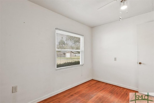 unfurnished room with hardwood / wood-style flooring, ceiling fan, and baseboards