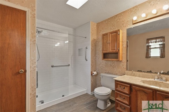 full bath featuring a textured ceiling, tiled shower, toilet, and wallpapered walls