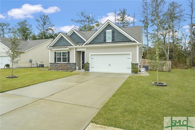 craftsman-style house with concrete driveway, an attached garage, central AC unit, a front yard, and stone siding