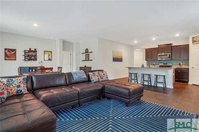 living area with dark wood-style flooring and recessed lighting