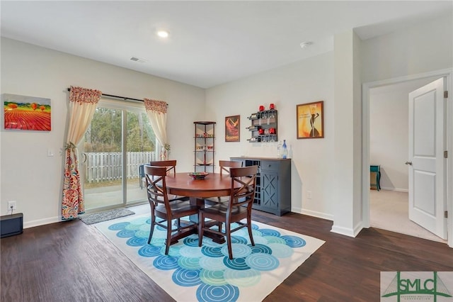 dining area featuring wood finished floors, visible vents, and baseboards