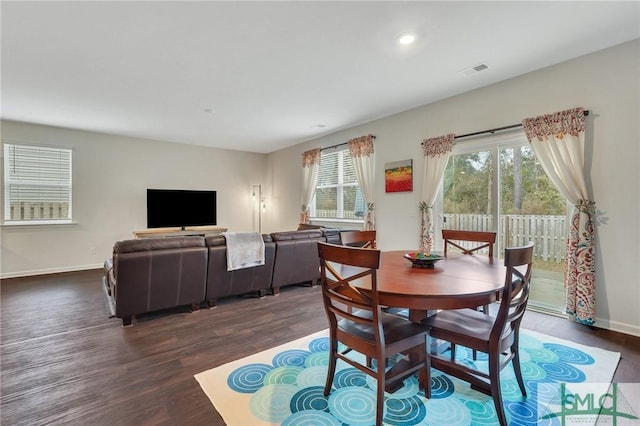 dining room featuring dark wood-type flooring, visible vents, plenty of natural light, and baseboards