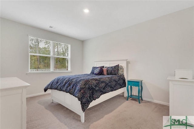 bedroom featuring visible vents, baseboards, and light colored carpet