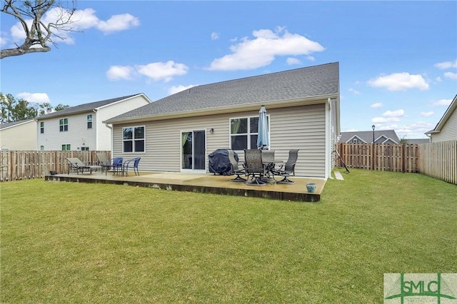 back of house with a lawn and a fenced backyard