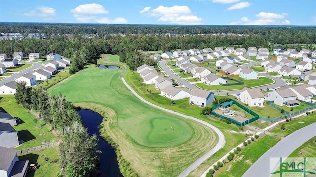 drone / aerial view featuring golf course view, a water view, and a residential view