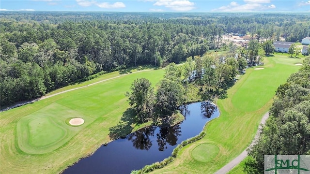 birds eye view of property featuring view of golf course, a water view, and a wooded view