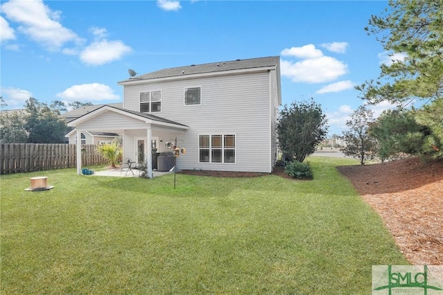 rear view of property with a yard, a patio area, and fence