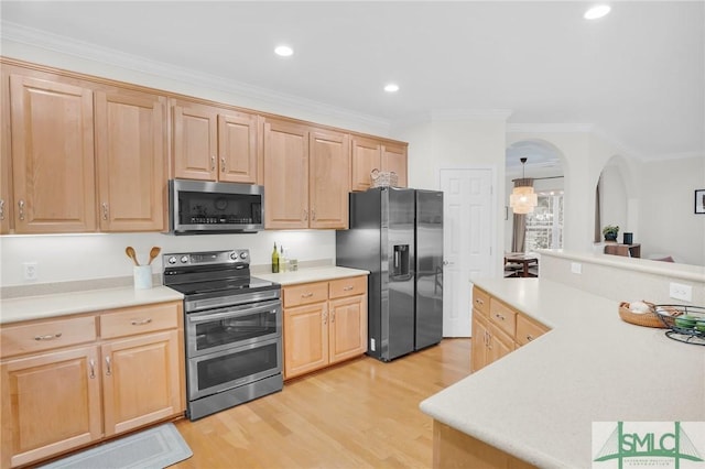 kitchen featuring stainless steel appliances, light countertops, light brown cabinets, and ornamental molding