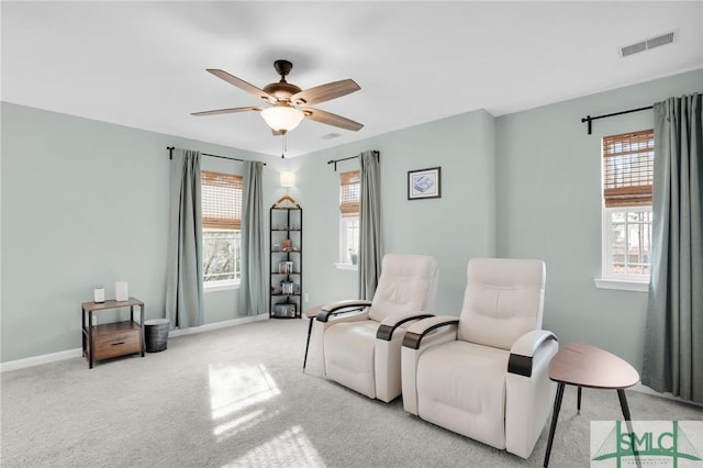 living area with baseboards, carpet flooring, visible vents, and a ceiling fan