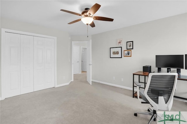 carpeted home office featuring baseboards and a ceiling fan