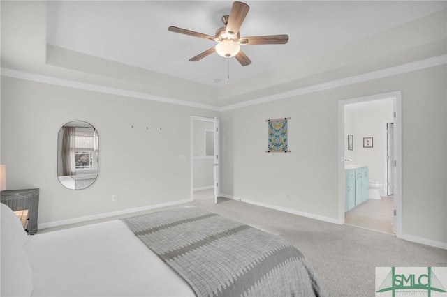 bedroom with ornamental molding, a tray ceiling, light colored carpet, and baseboards