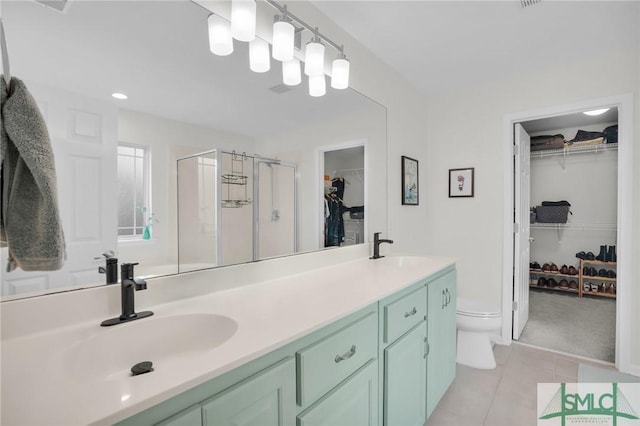 bathroom with a sink, a shower stall, toilet, and double vanity