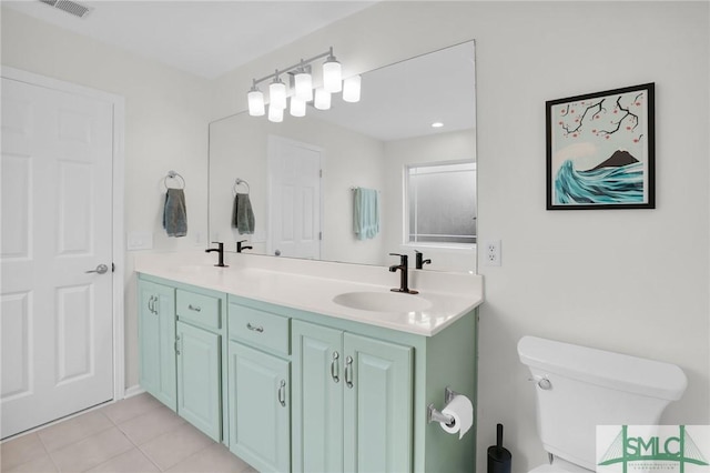 bathroom with visible vents, double vanity, a sink, and toilet