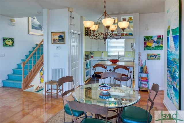 dining room featuring visible vents, stairway, and an inviting chandelier