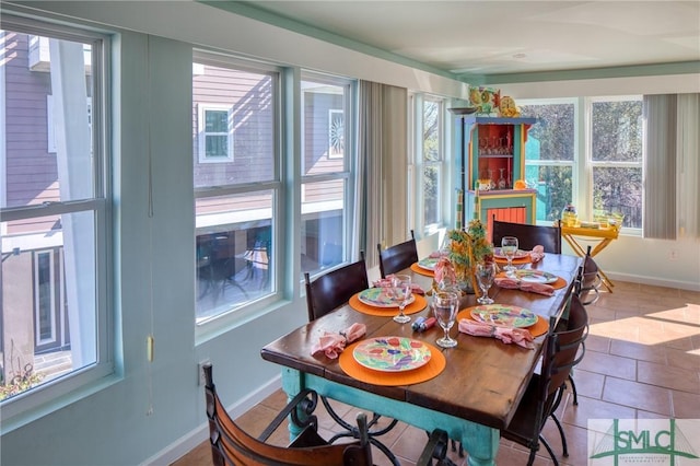 tiled dining space featuring baseboards