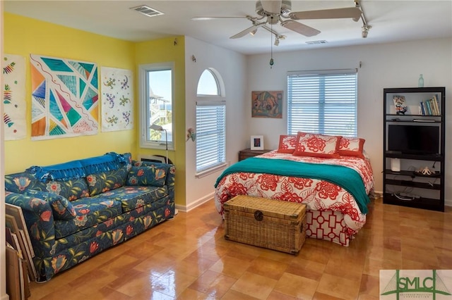 bedroom with ceiling fan, track lighting, visible vents, and baseboards