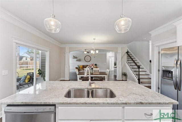 kitchen with a sink, white cabinets, ornamental molding, appliances with stainless steel finishes, and decorative columns