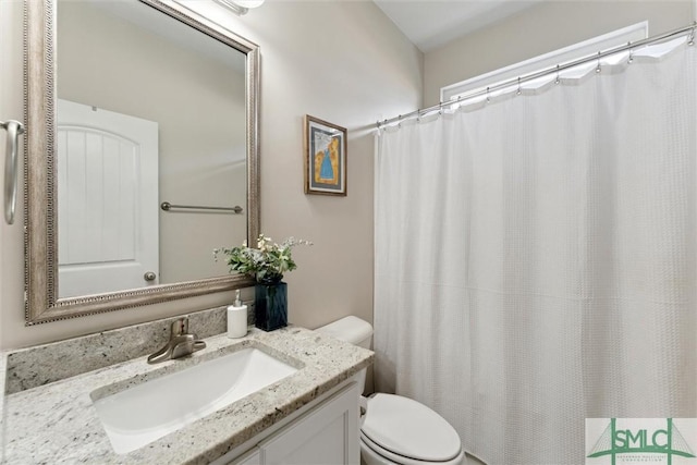 full bath with curtained shower, vanity, and toilet