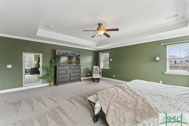 carpeted bedroom with baseboards, visible vents, a ceiling fan, a raised ceiling, and crown molding