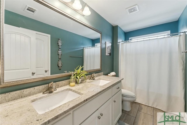 bathroom featuring visible vents, a sink, and toilet