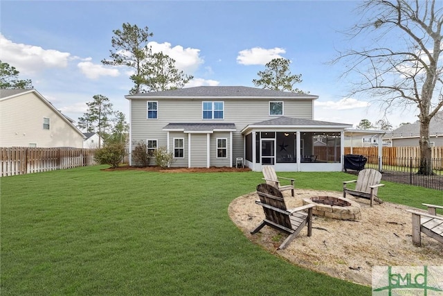 rear view of house with a fire pit, a lawn, a fenced backyard, and a sunroom