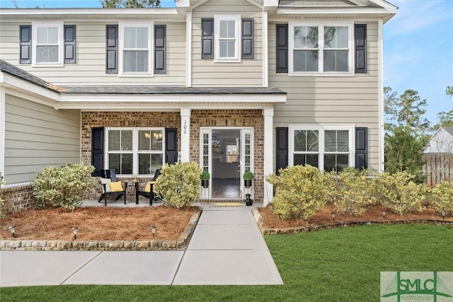 view of front of home featuring brick siding and a front yard