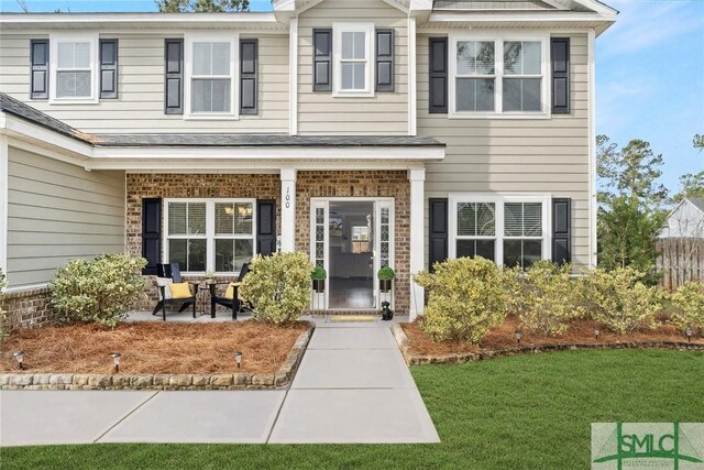 100 Timberland Trl, Richmond Hill, GA 31324 - view of front of house featuring brick siding, a front yard, and a shingled roof
