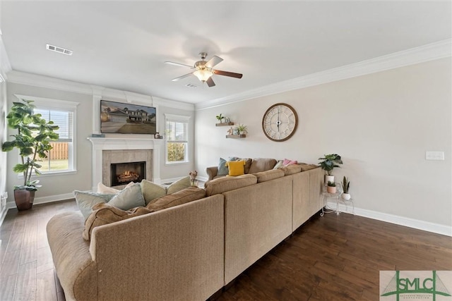 living room with dark wood-style floors, ornamental molding, and a wealth of natural light